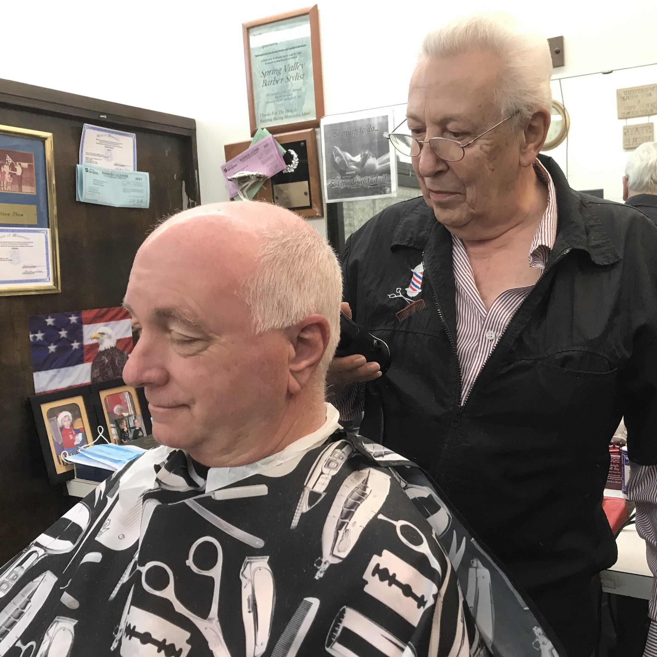 A barber cuts a customer's hair
