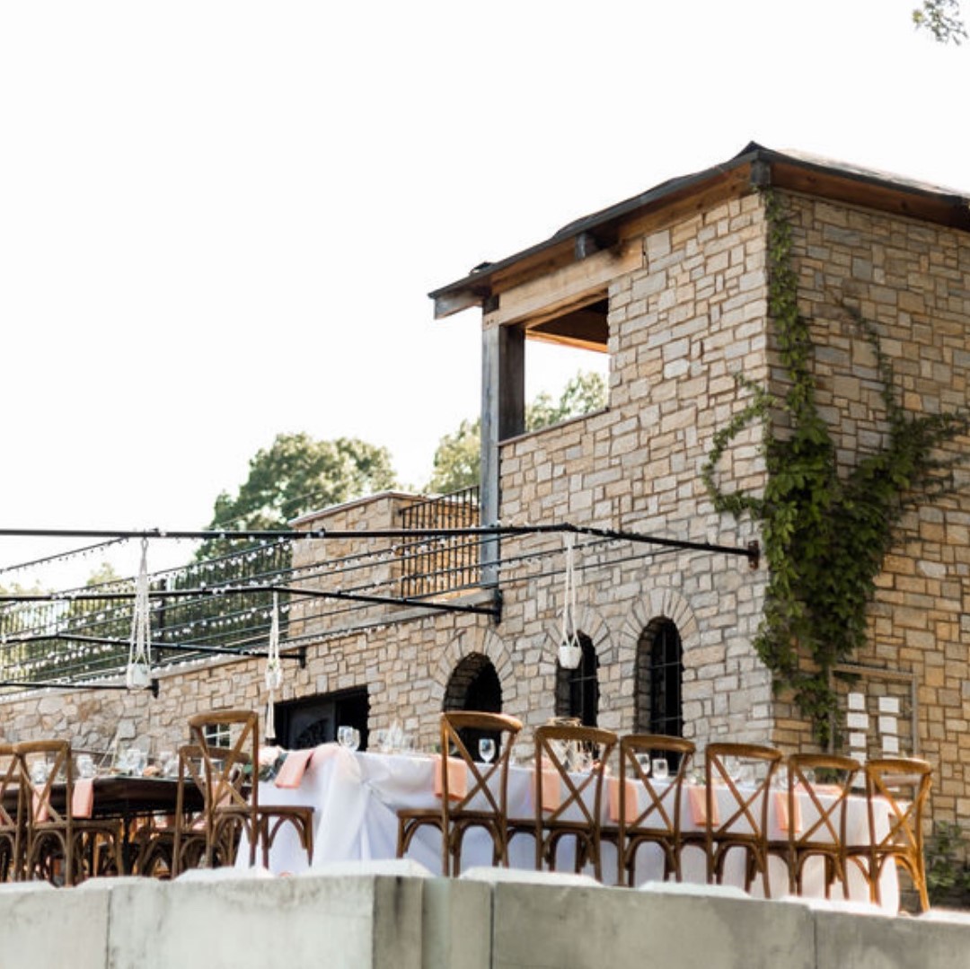 Cassell Vineyards' stone building with tables set up on its patio for an event