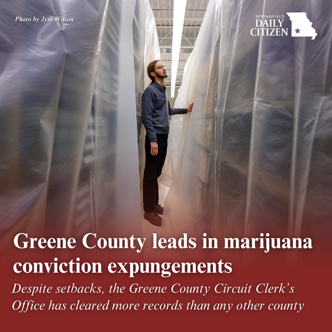 Greene County Circuit Court deputy clerk Jonathan Zachary walks down one of the rows of boxes of court records in the court’s archive building. Text on the image reads: "Greene County leads in marijuana conviction expungements. Despite setbacks, the Greene County Circuit Clerk's Office has cleared more records than any other county." (Photo by Jym Wilson)