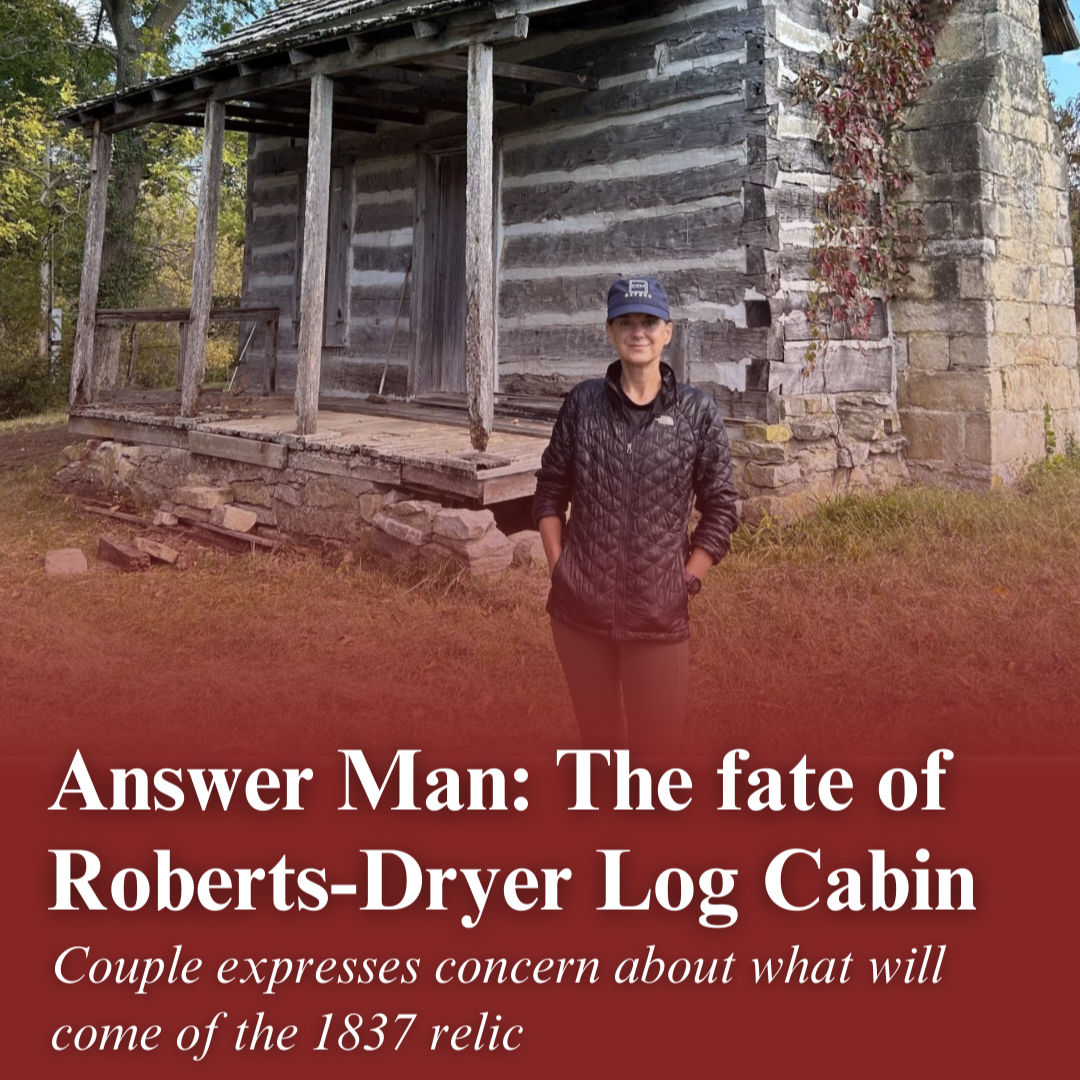 Jodi Hamilton in front of a log cabin on her Greene County property east of Springfield. Text over the image reads, "Answer Man: The fate of Roberts-Dryer Log Cabin. Couple expresses concern about what will come of the 1837 relic."