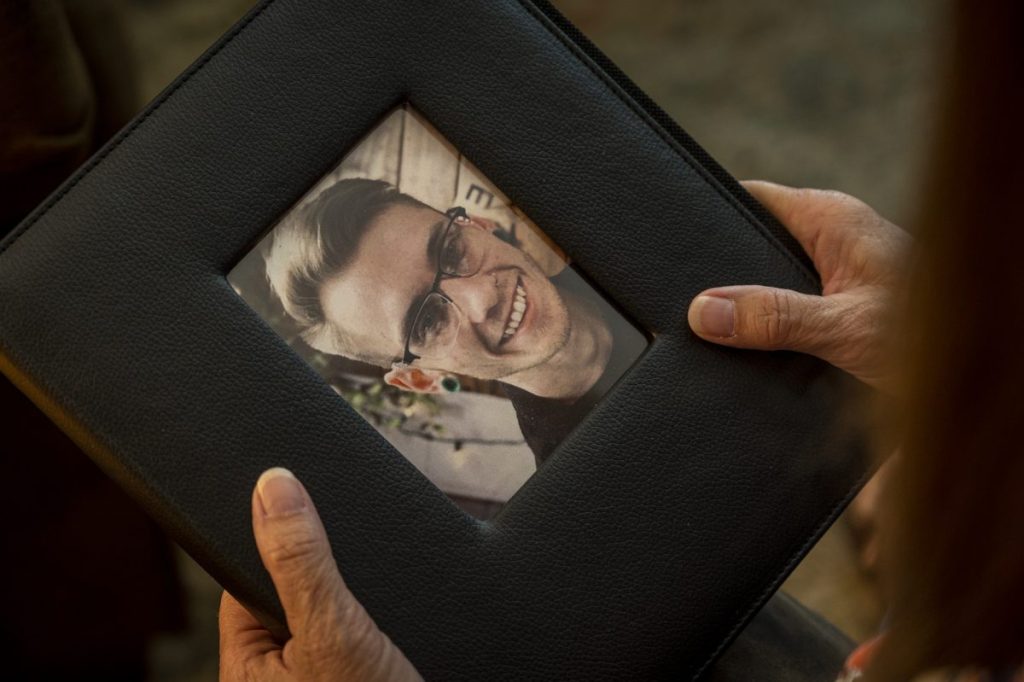 Carol Winslow holds the memorial book from her son Sean's funeral. She chose the photo for the smile that it captured.