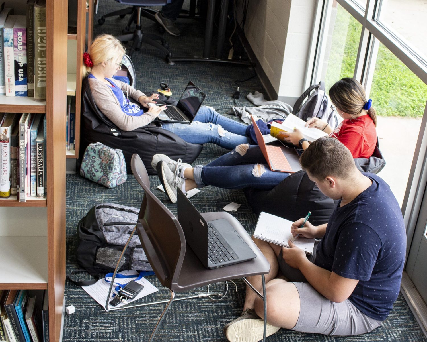 High school students study on laptops.