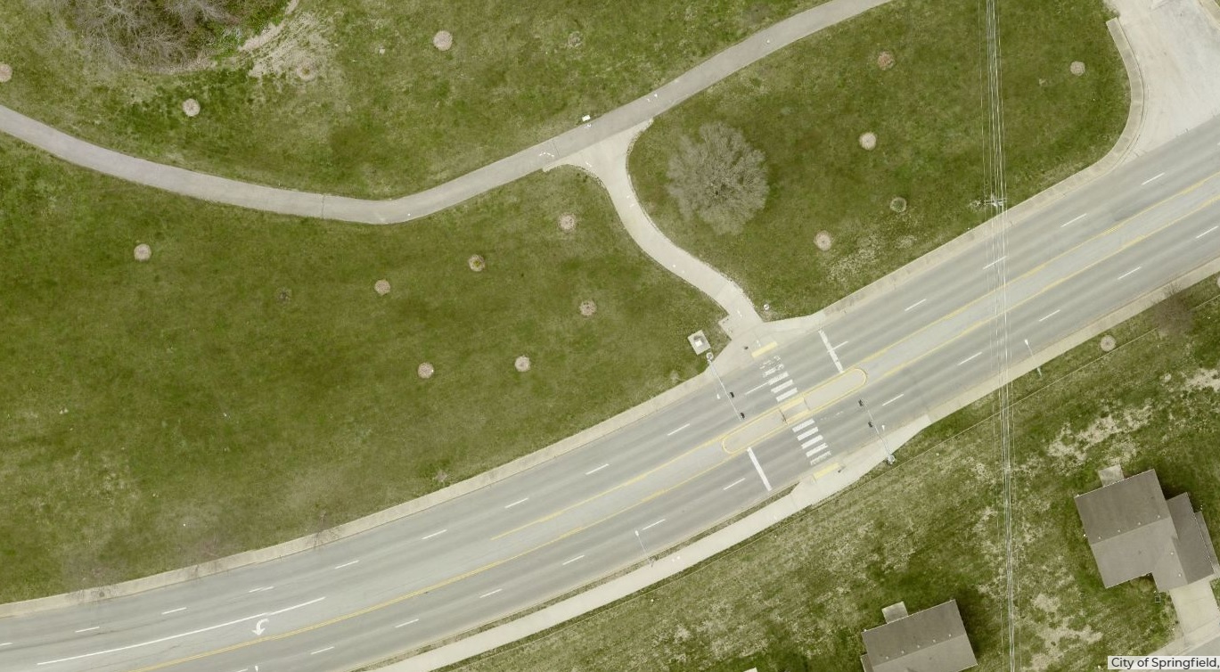 A top view aerial photograph shows where a pedestrian crossing spans Sunset Street