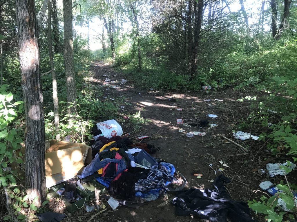 This is the site of a former homeless camp in west Springfield. There are items of trash and clothing scattered about the woods.
