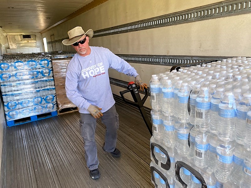 Man loads bottles of water into truck.