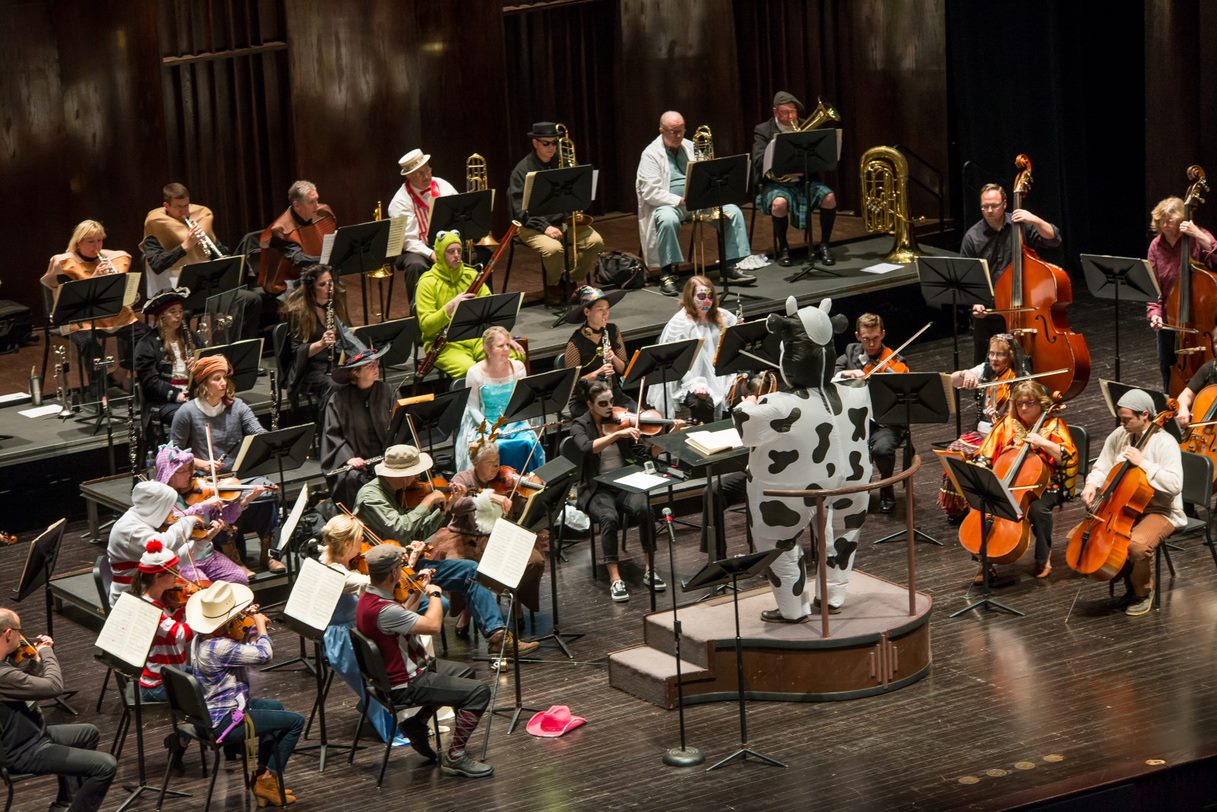 A symphony orchestra performs while wearing Halloween costumes