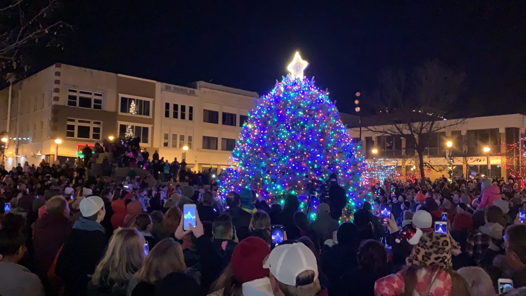 A crowd gathers around a 30-foot-tall Christmas tree