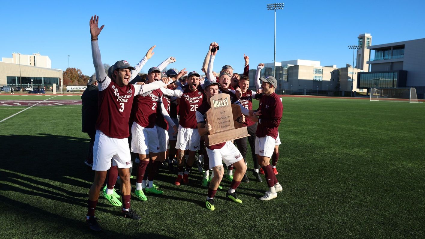 A soccer team celebrates with a trophy