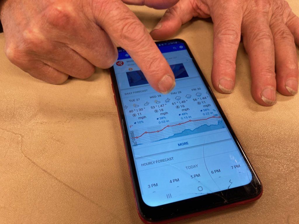 A man named David, who came to the emergency warming shelter at the Expo Center on Thursday, shows next week's forecast on his phone. On this day, Dec. 22, 2022, the temperature with wind chill was well below freezing. In a week, it will be in the 60s.