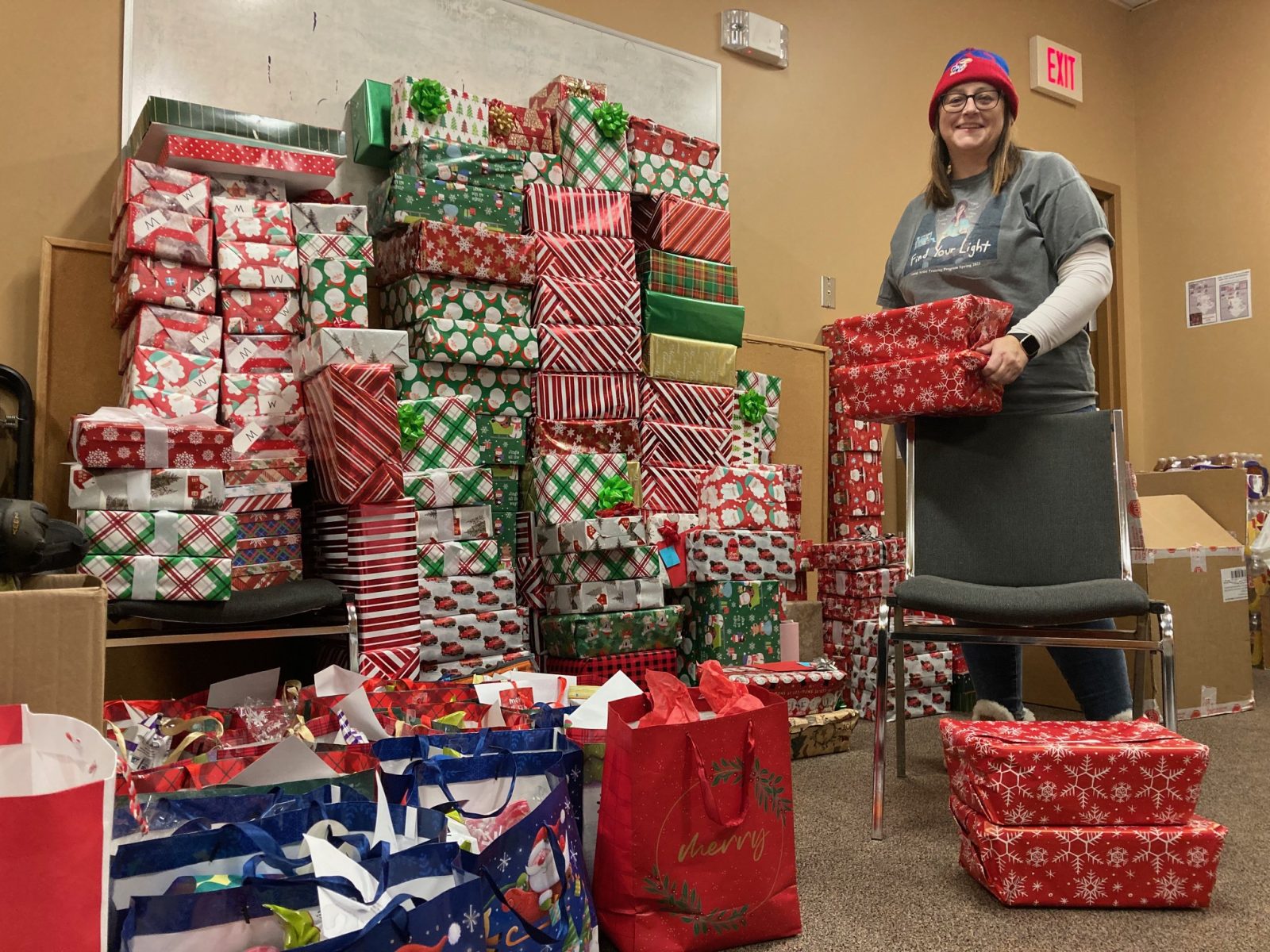 Homeless advocate and volunteer Katrin Scott stands with more than 200 wrapped gifts she plans to deliver to the cold weather shelters on Christmas Eve.