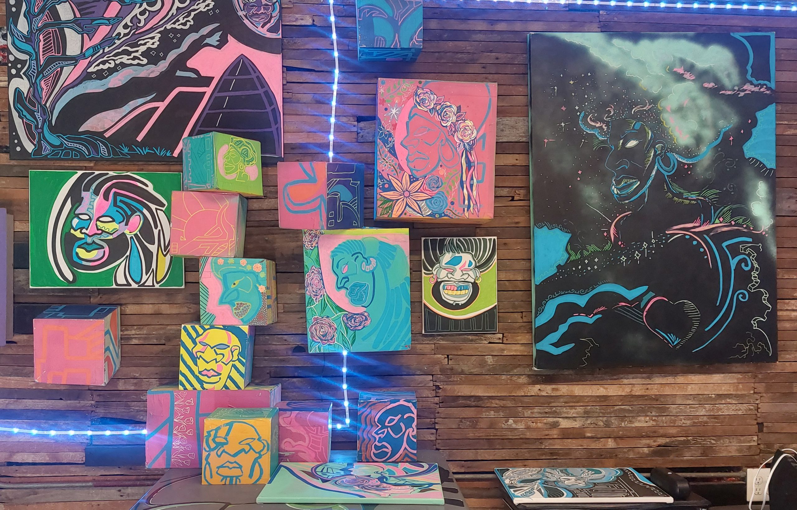 Brightly-colored paintings sit on a table