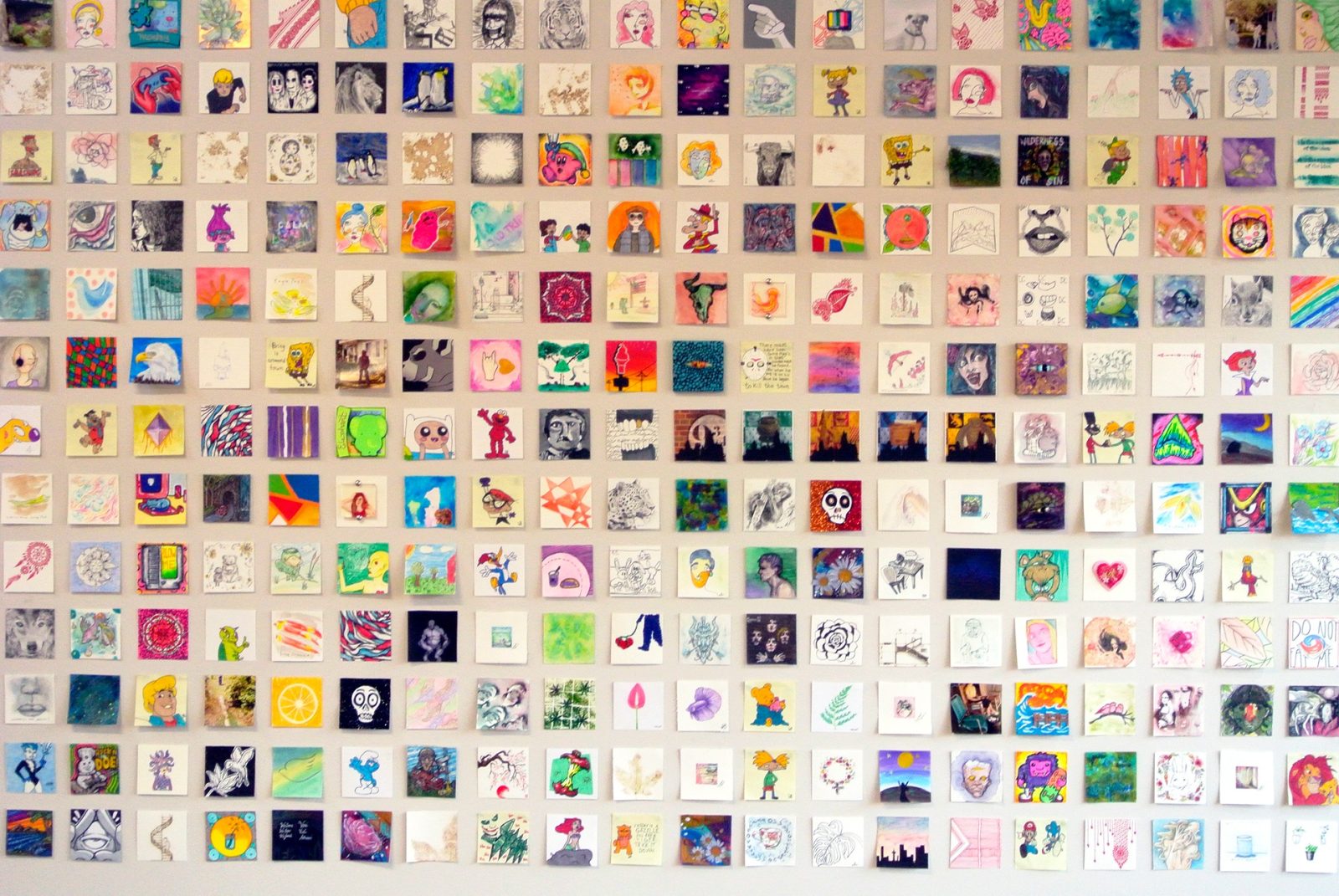 A wall of Post-It-sized pieces of art