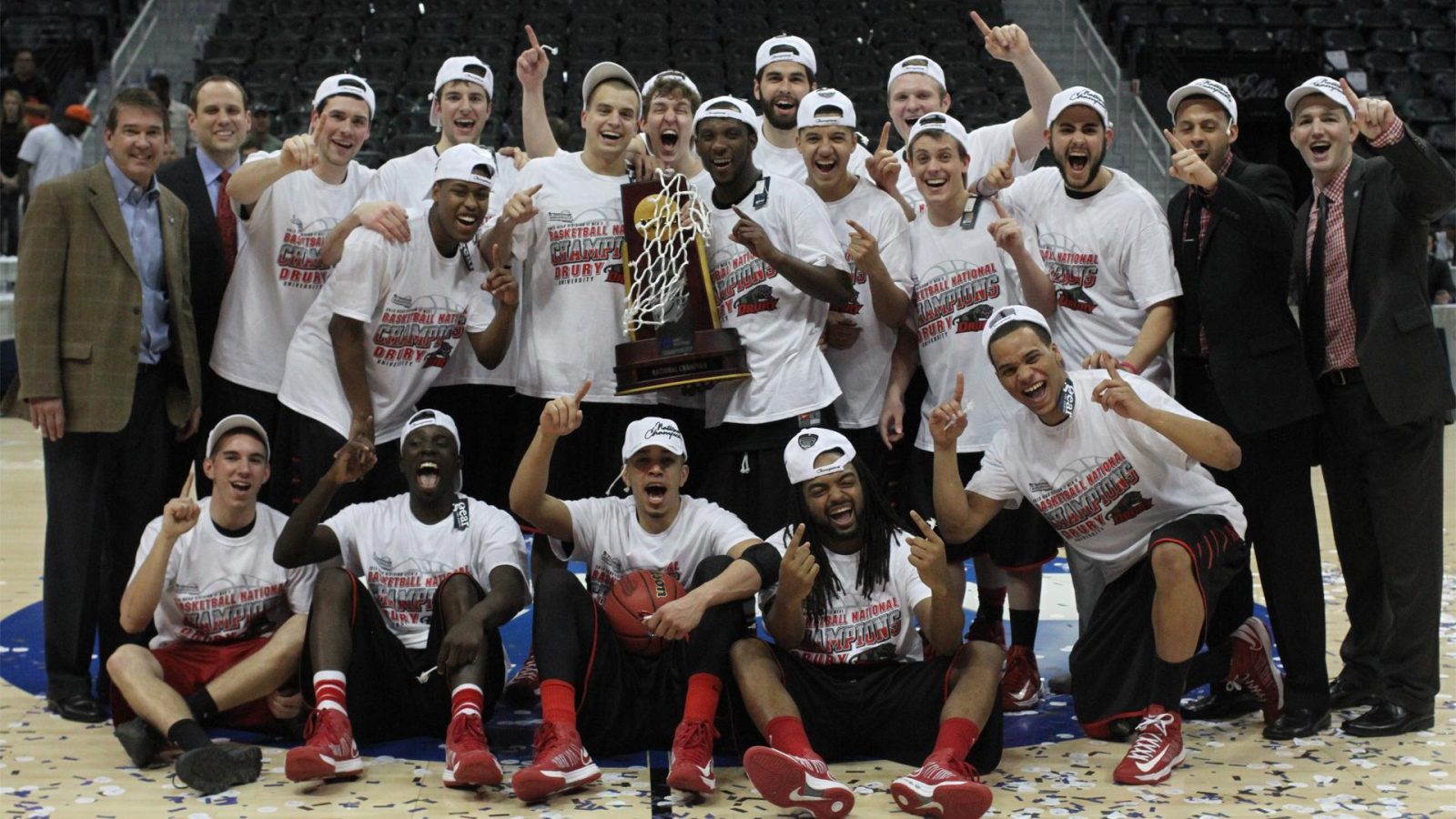 Basketball players pose with their trophy after winning the NCAA Division II National Championship