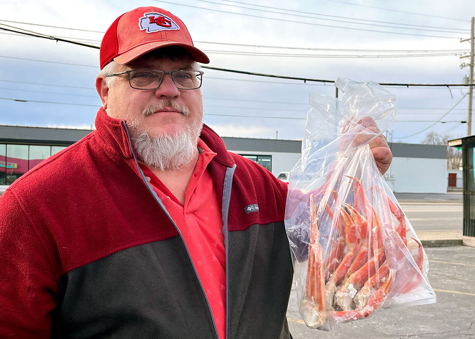 A man holding a bag of crab legs