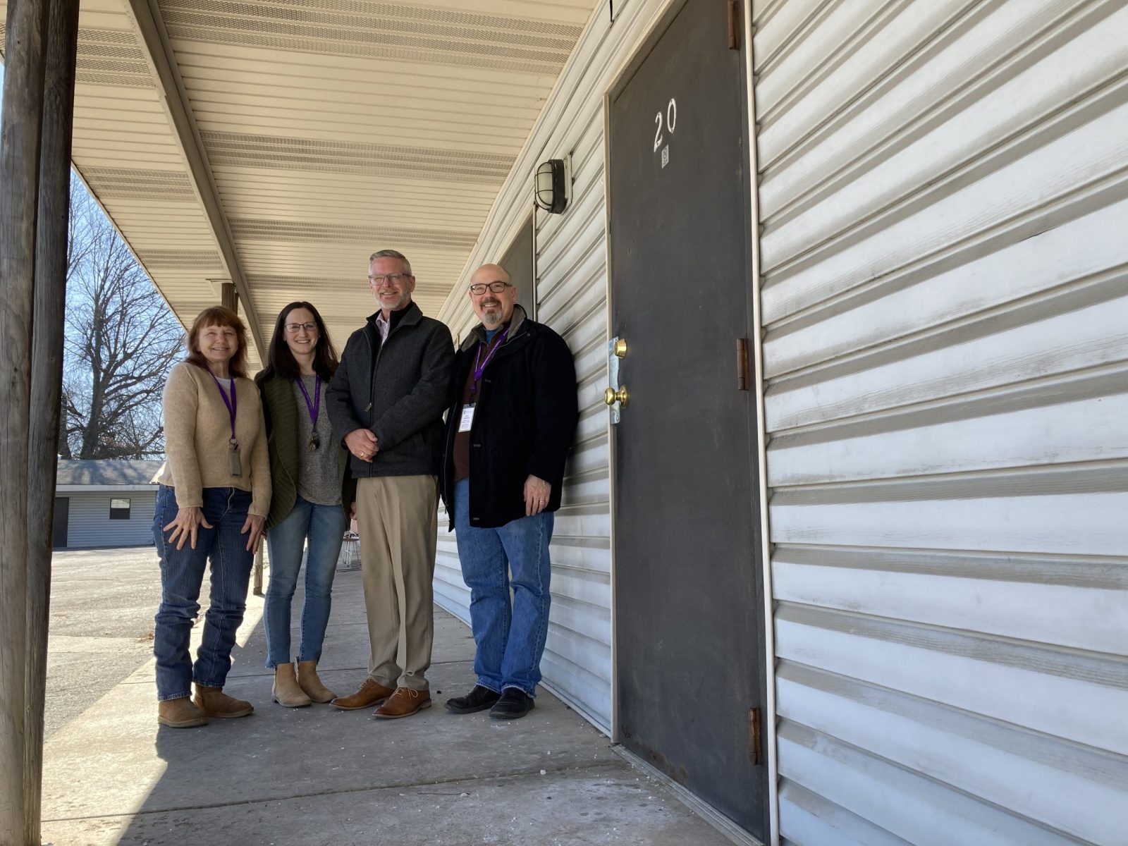 Pictured in front of the Rancho Emergency Shelter (from left) are Michelle Johnson, housing case manager; Rachel Davis, program manager; Ken Palermo, executive director of Catholic Charities of Southern Missouri; and John Lunardini, director of Social Enterprise and Facilities for Catholic Charities. (Photo by Jackie Rehwald)