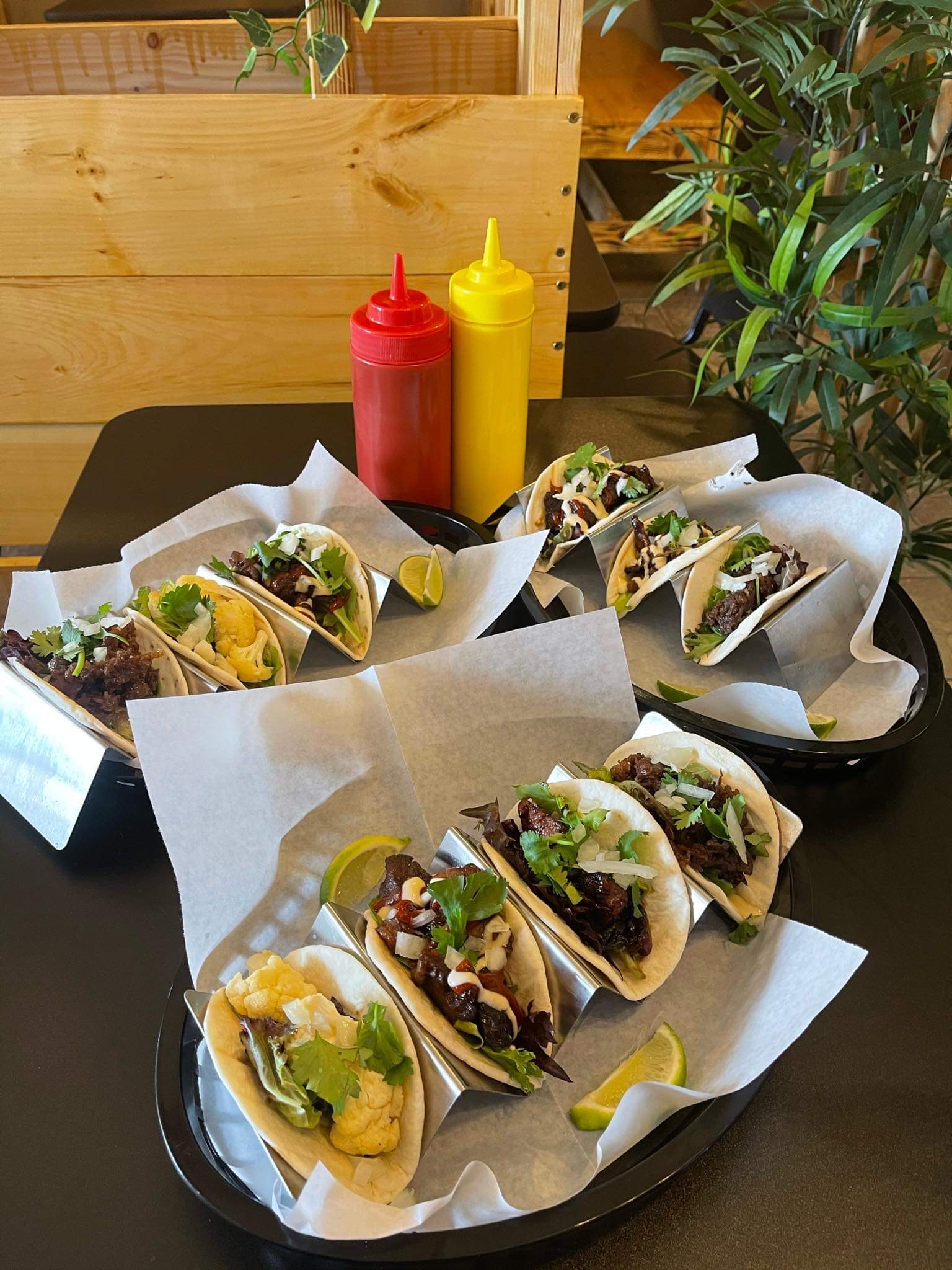 Three plates of tacos sit on a table inside a restaurant