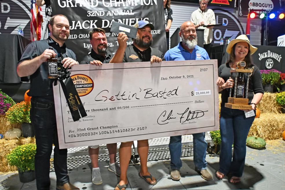 A competitive barbecue poses with an oversized check