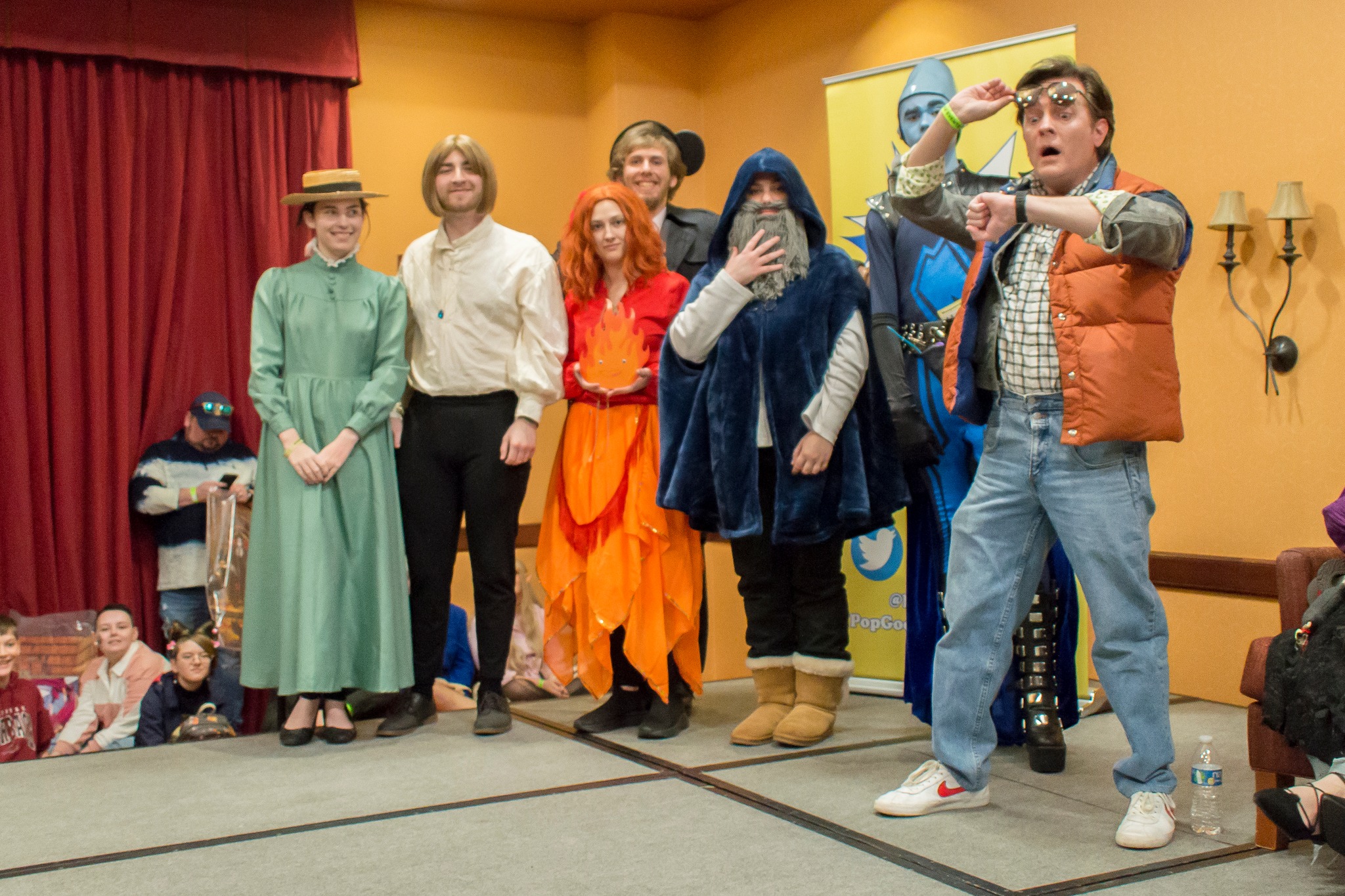 A group of people dressed in cosplay stand on a stage