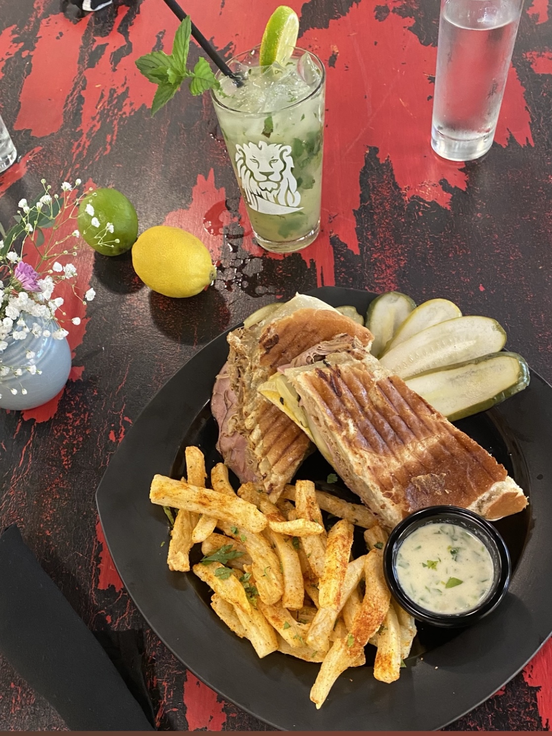 A Cuban sandwich and yuca fries sit on a plate