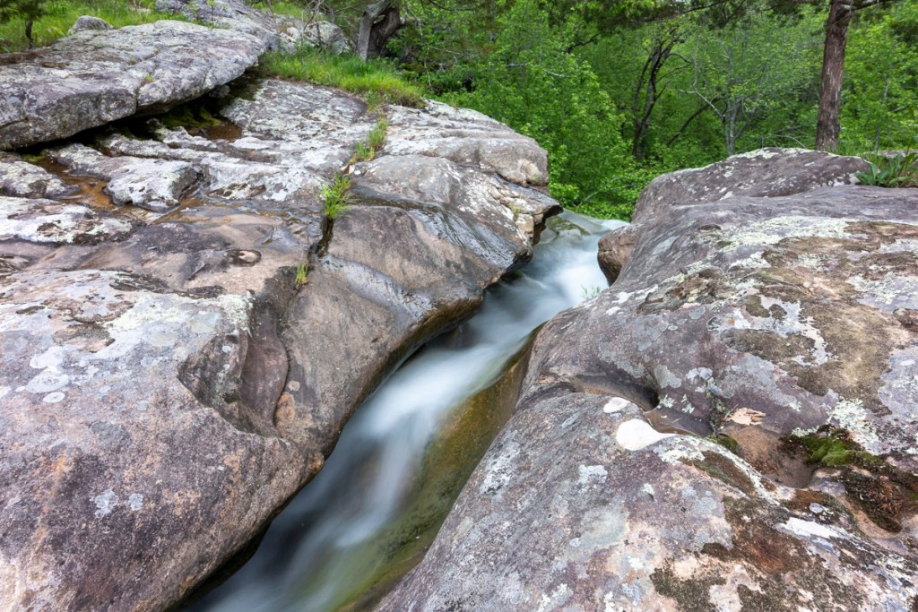A creek flows between two stone ledges
