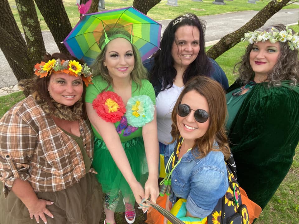 A group of five women, dressed in weather-related costumes, pose for a phohto