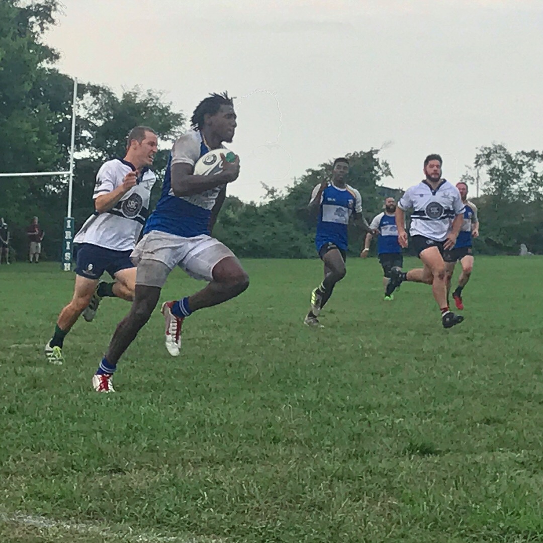 A rugby player runs with the ball