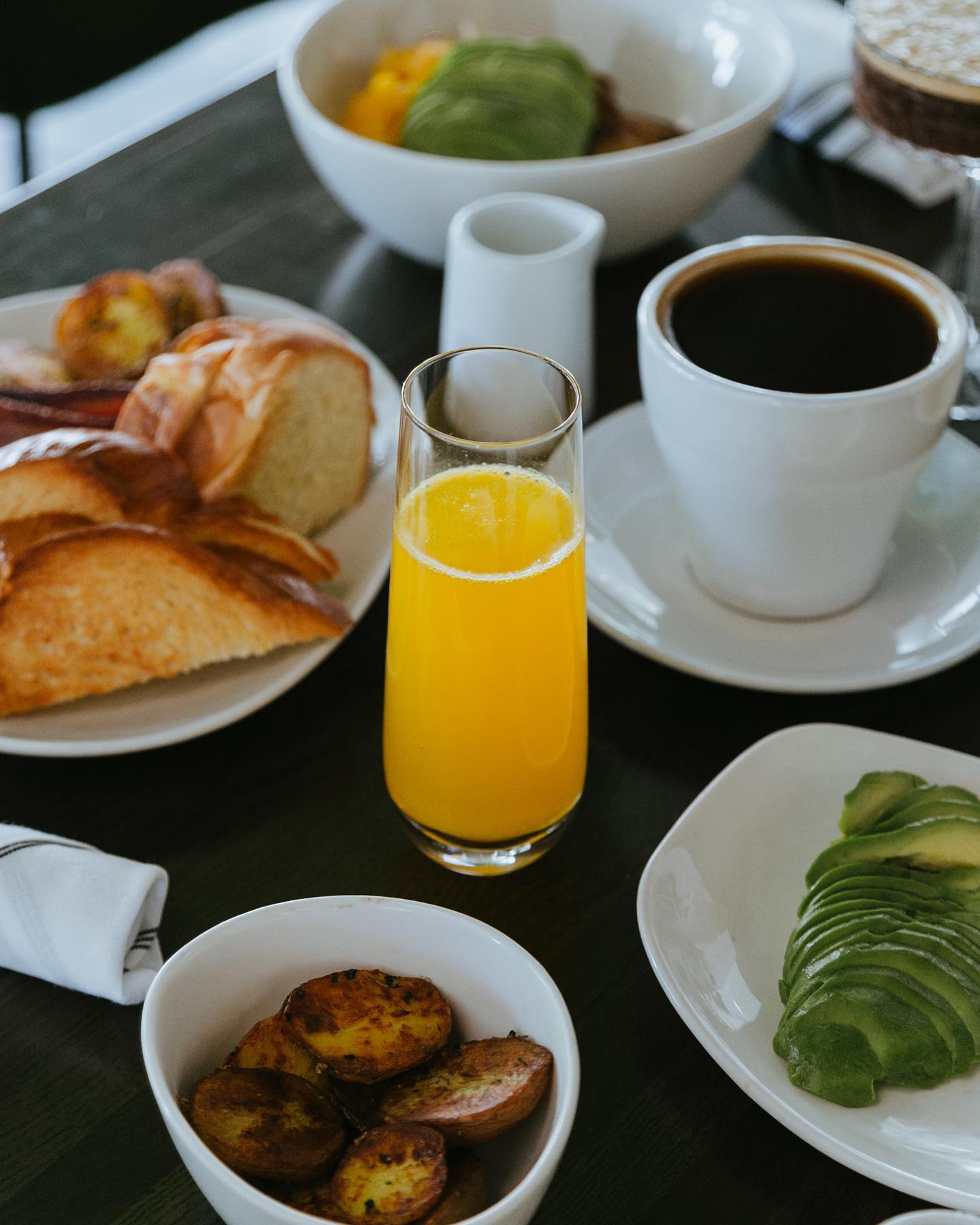 A restaurant table set with breakfast dishes, including a mimosa