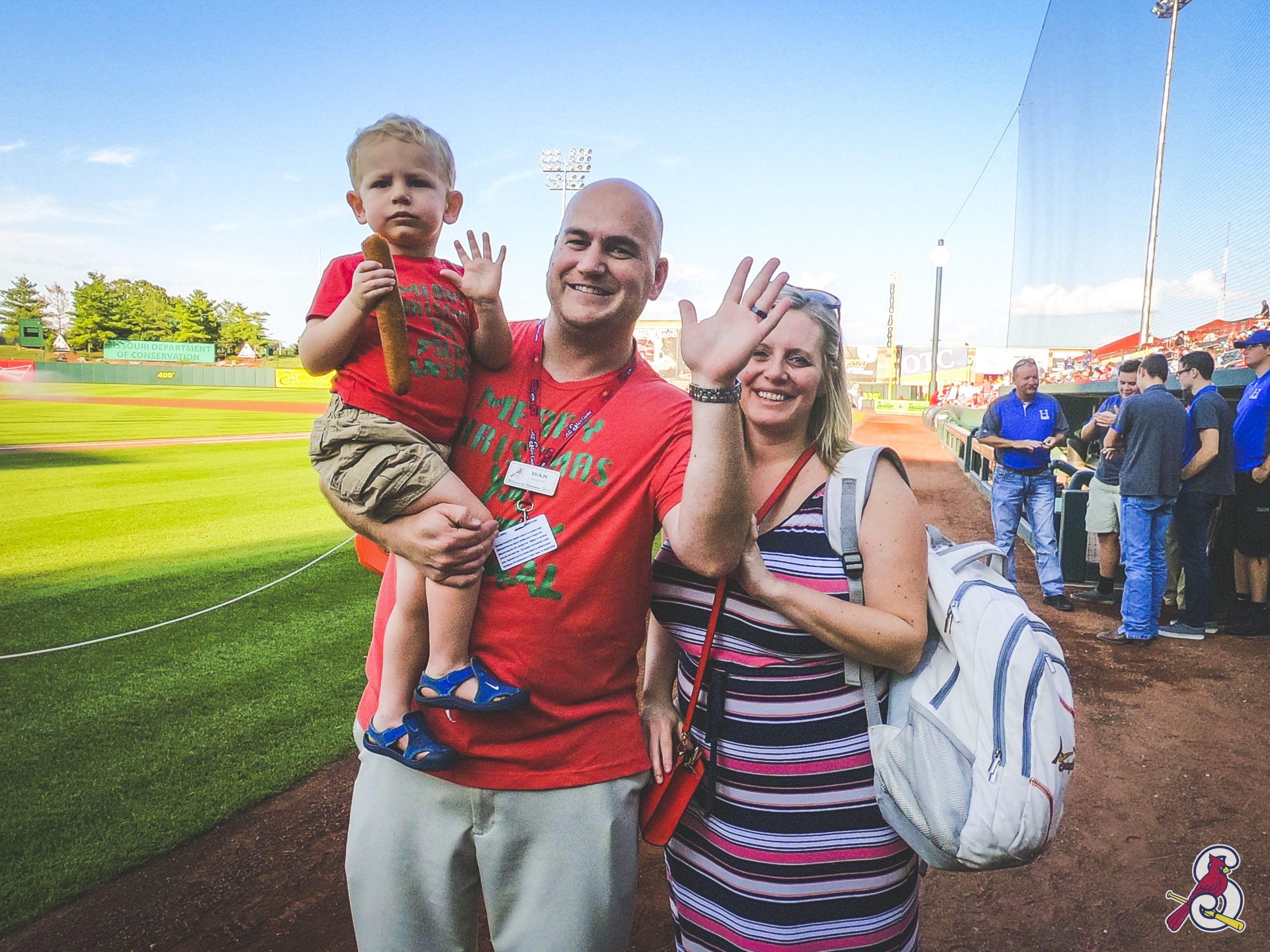 A father, mother and son pose for a picture at a baseball stadium