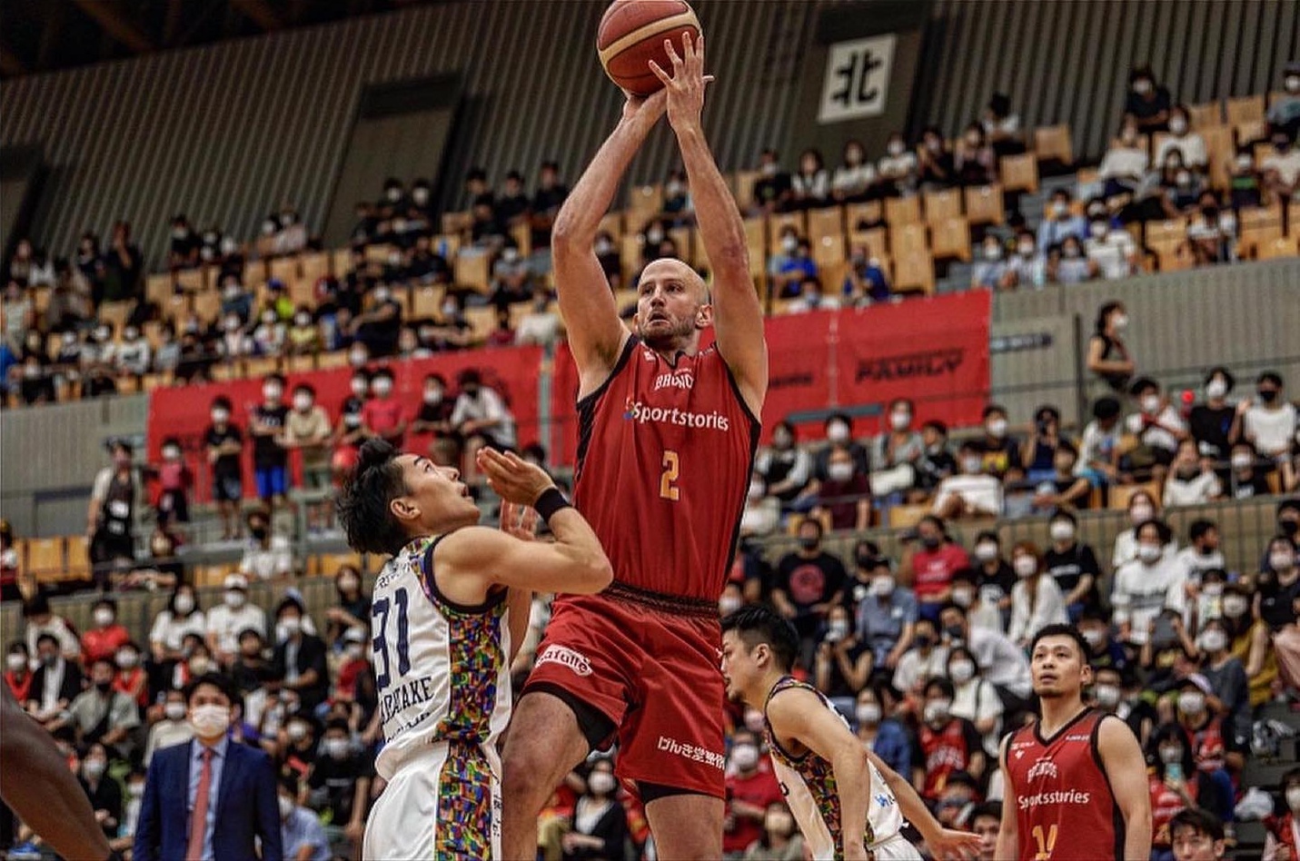 Will Creekmore shoots the ball over an opponent during a game in Japan