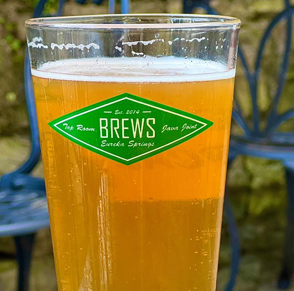 A pint of beer with the logo for Brews printed on the side of the glass