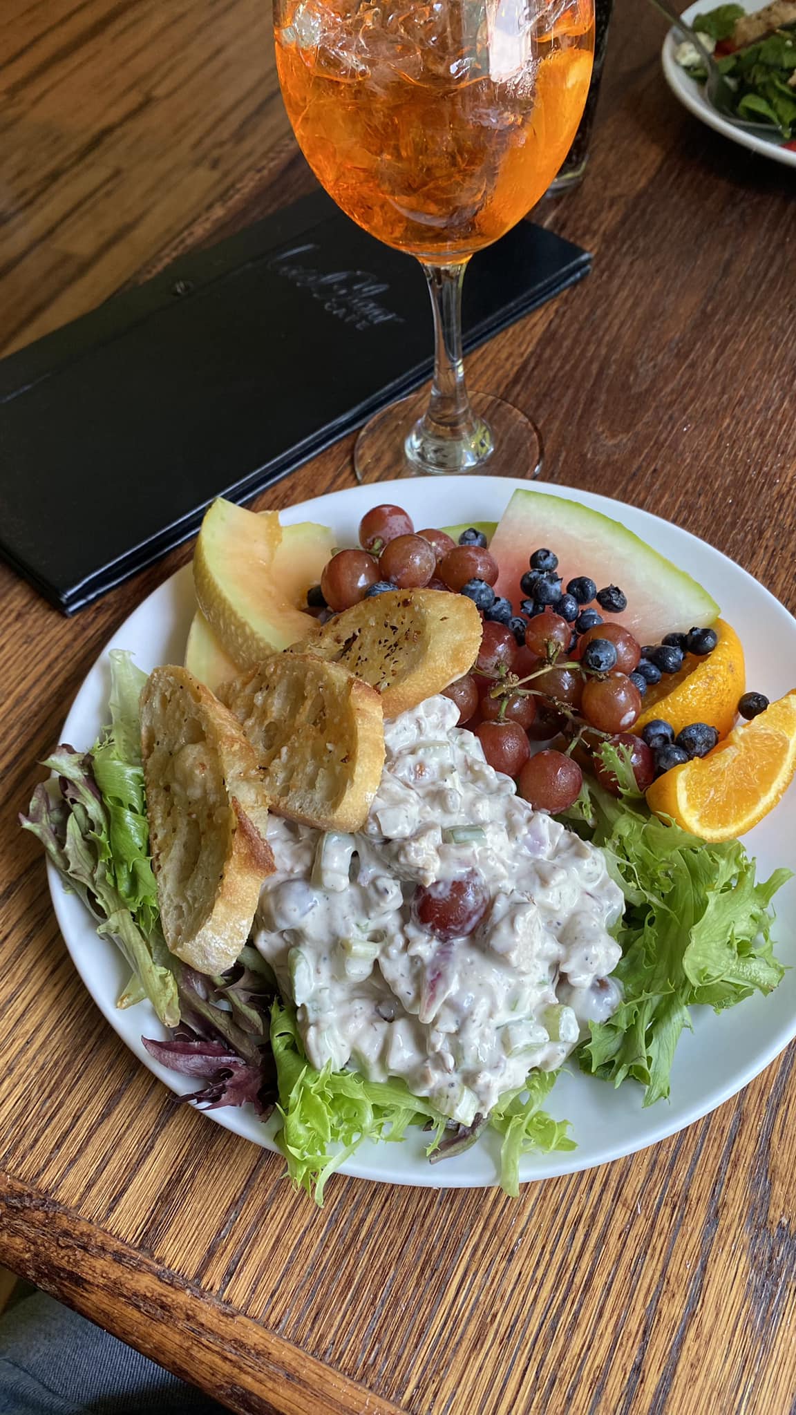 A salad sits on a plate on a table in a restaurant