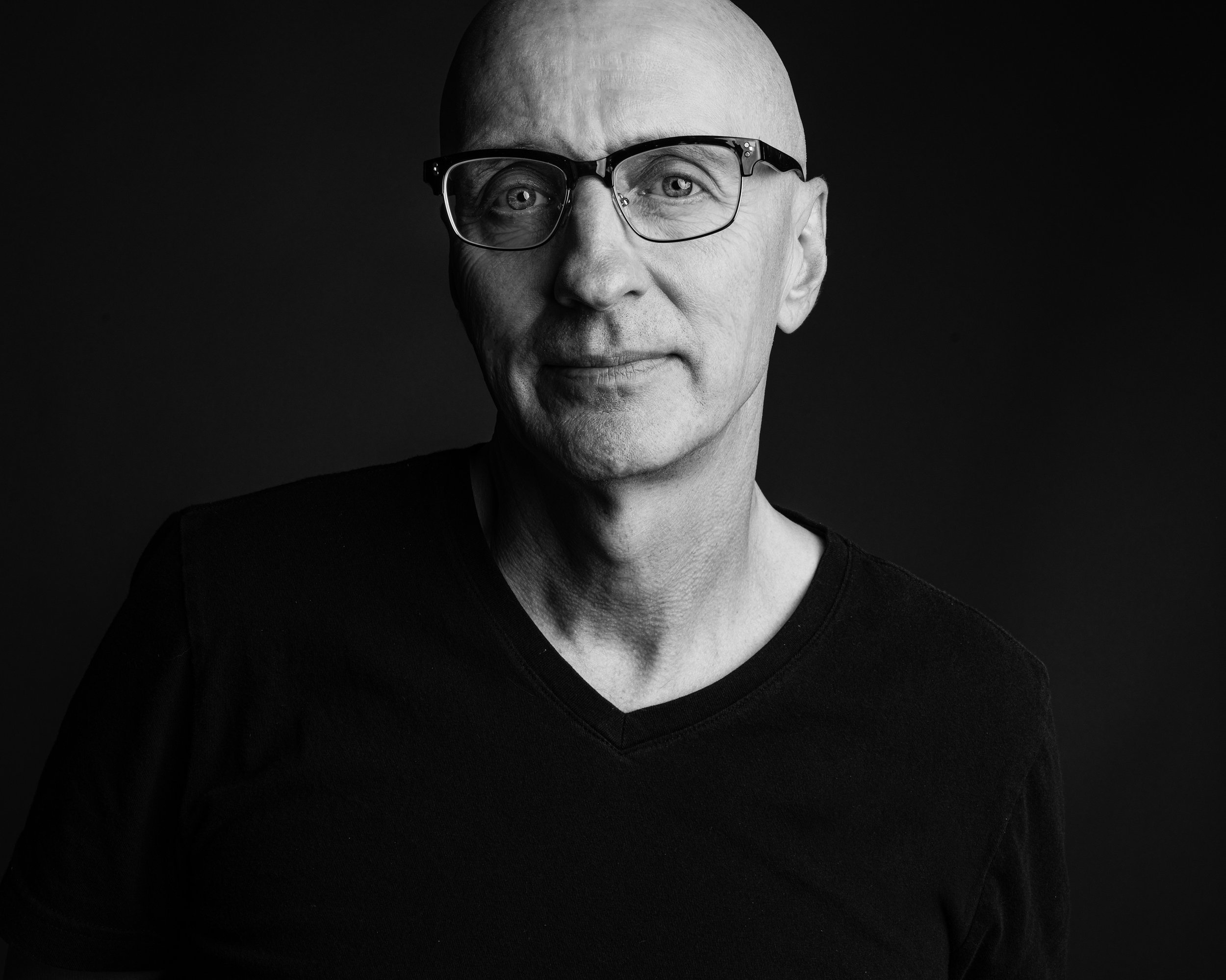 A black-and-white portrait photograph of photographer Randy Bacon