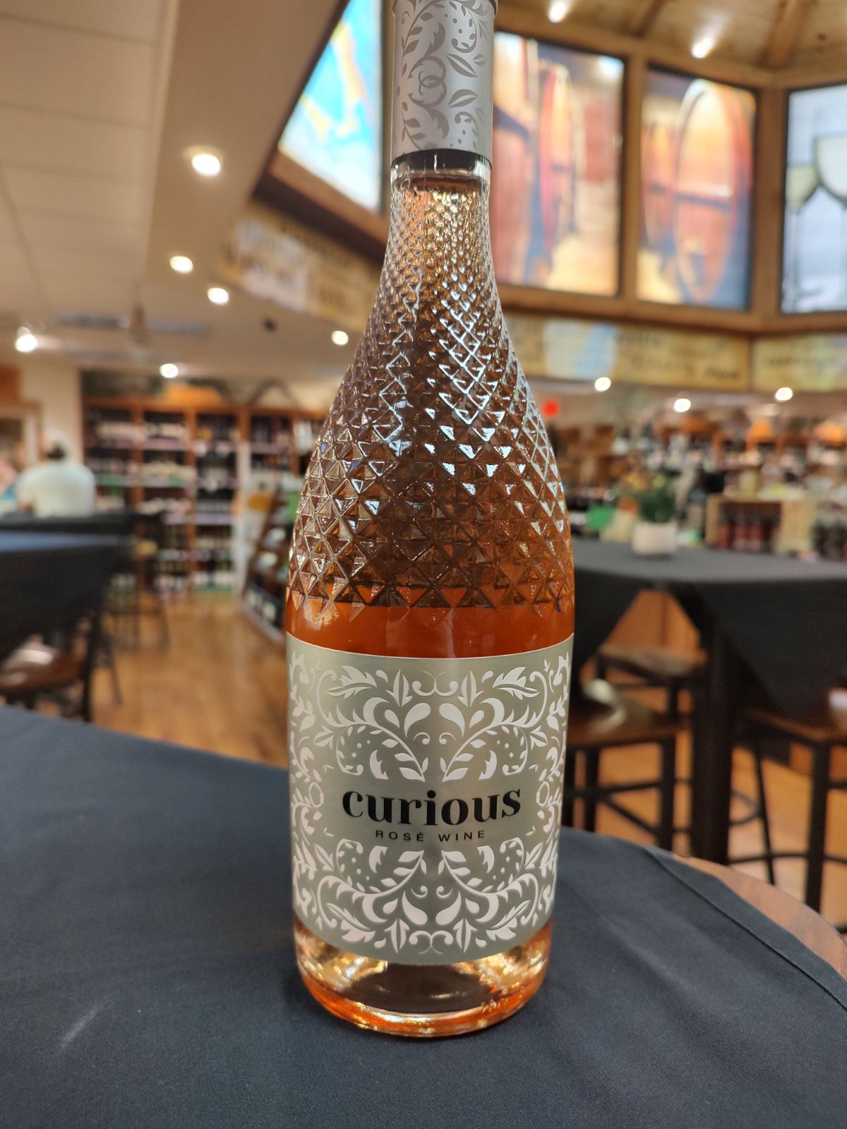A bottle of Curious rosé wine sits on a table at Macadoodles