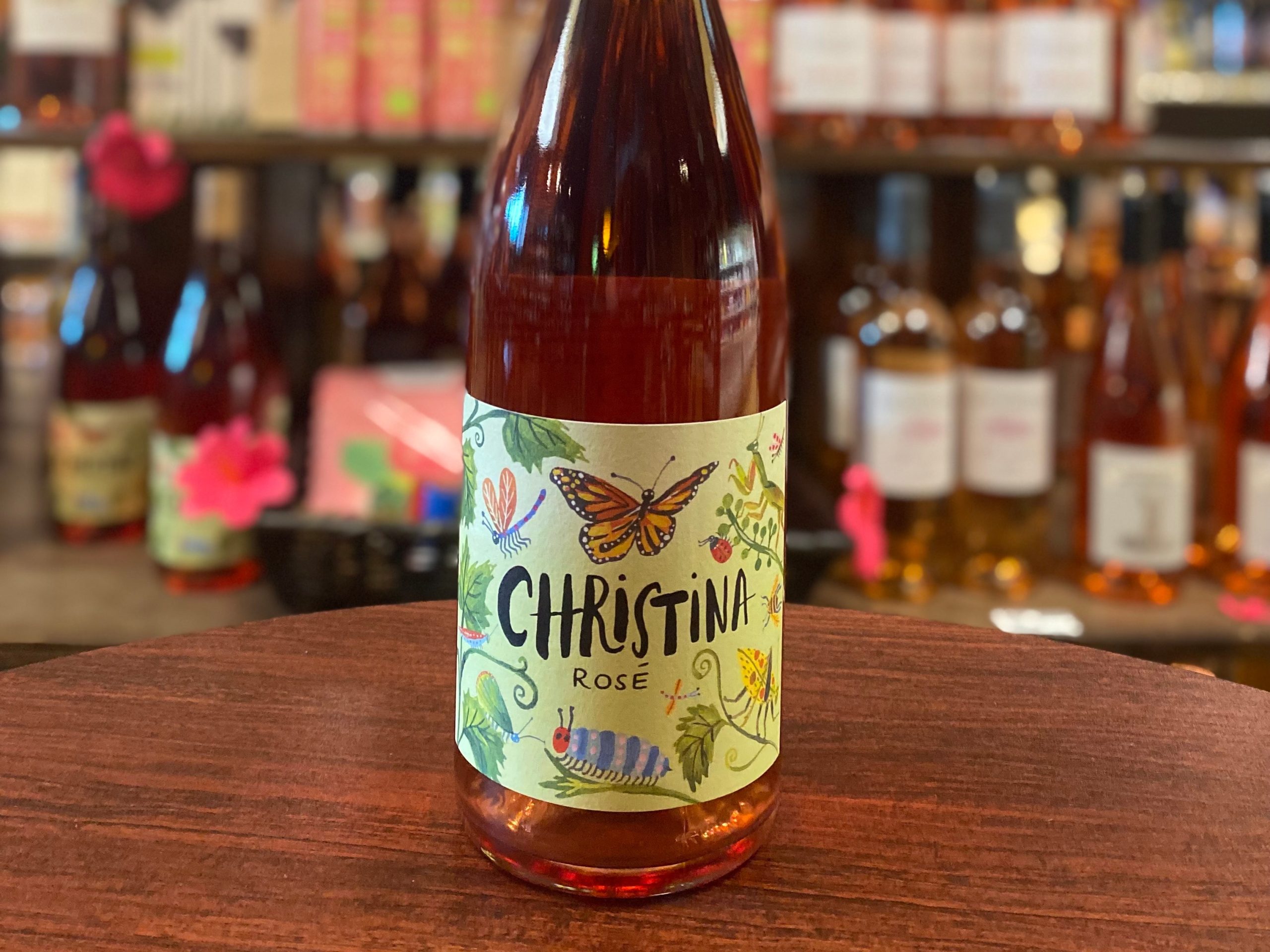 A bottle of Christina rosé sits on a wooden tabletop at Mama Jean's Natural Market