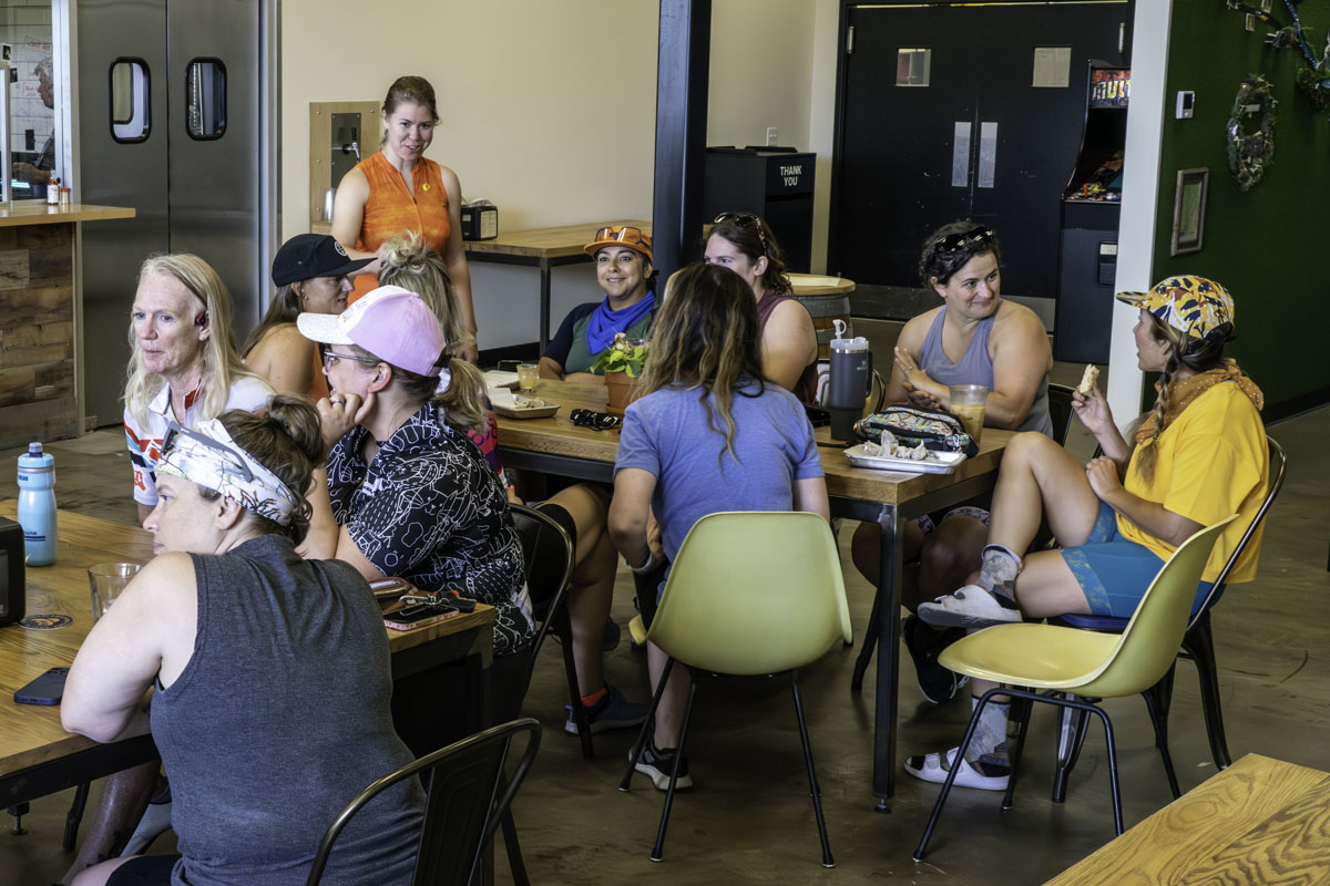 Groups of women sit at tables inside Before and After Brewing, eating, drinking coffee and chatting