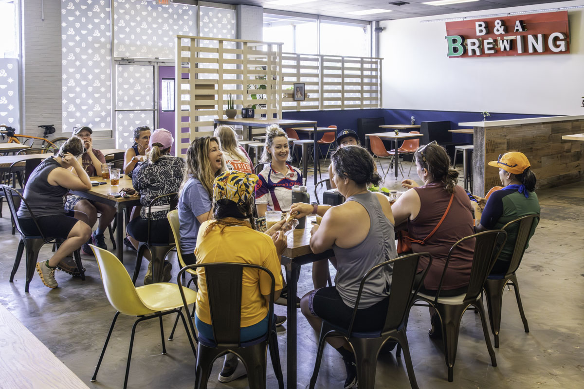 Groups of women sit at tables inside Before and After Brewing, eating, drinking coffee and chatting