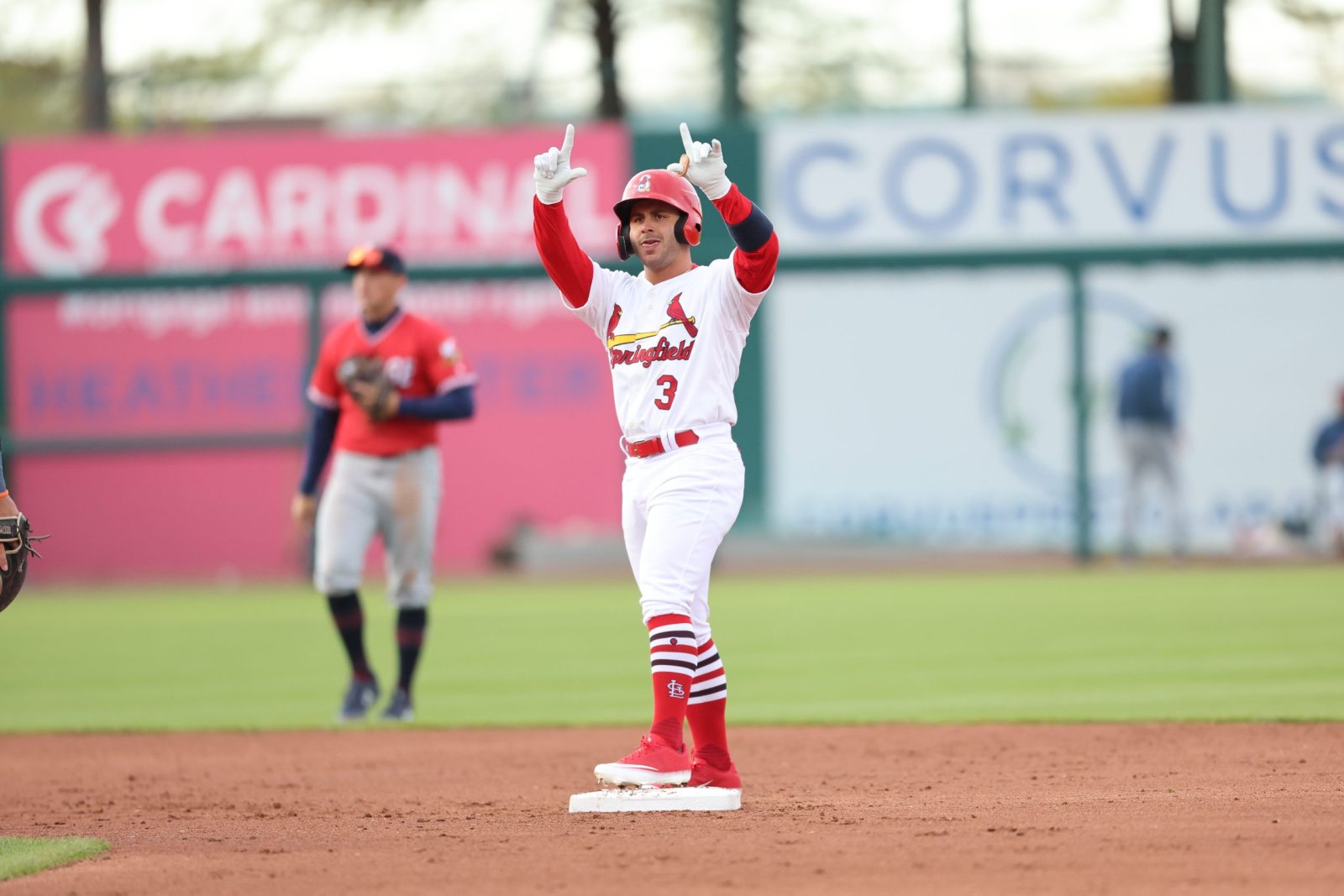 Mike Antico, wearing a Springfield Cardinals uniform, raises both arms at the dugout as he stands on second base