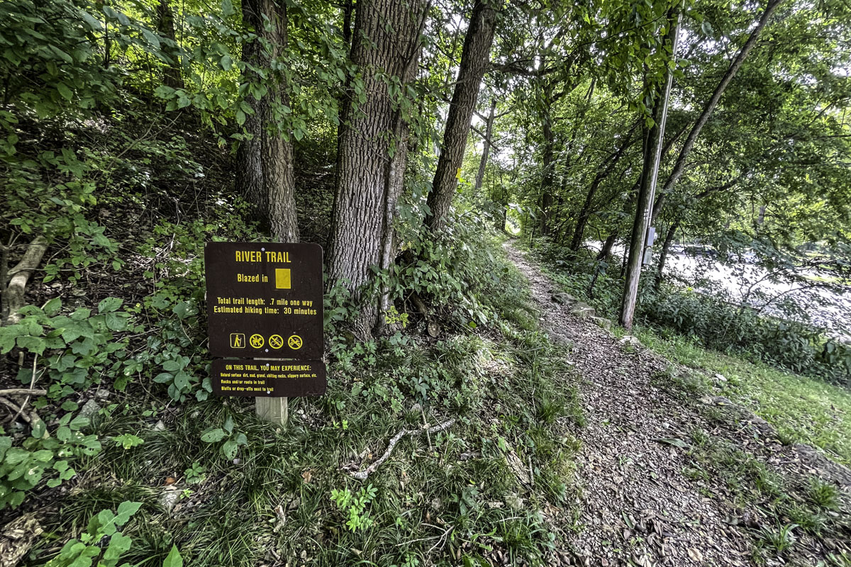 A brown wooden sign with yellow lettering for the River Trail at Roaring River State Park