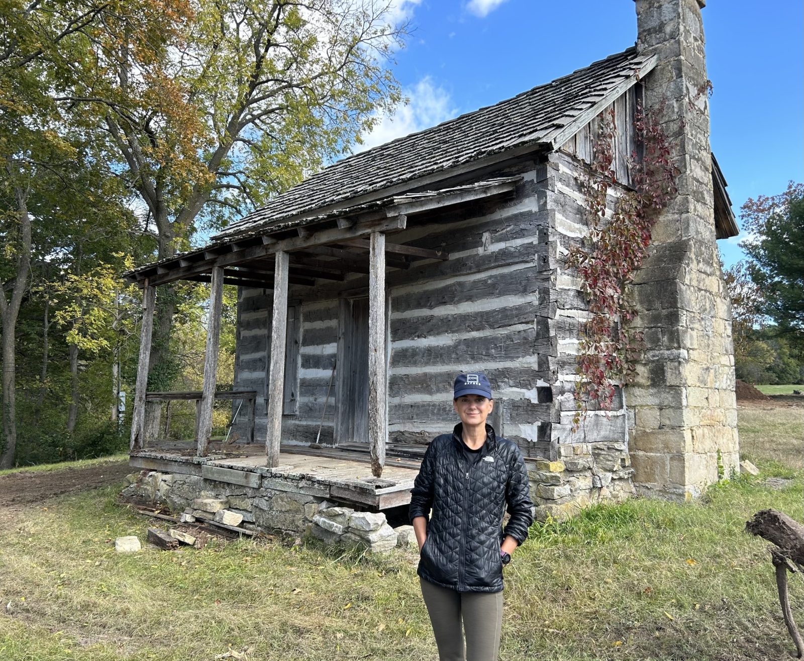 Jodi Hamilton in front of a log cabin on her Greene County property east of Springfield.