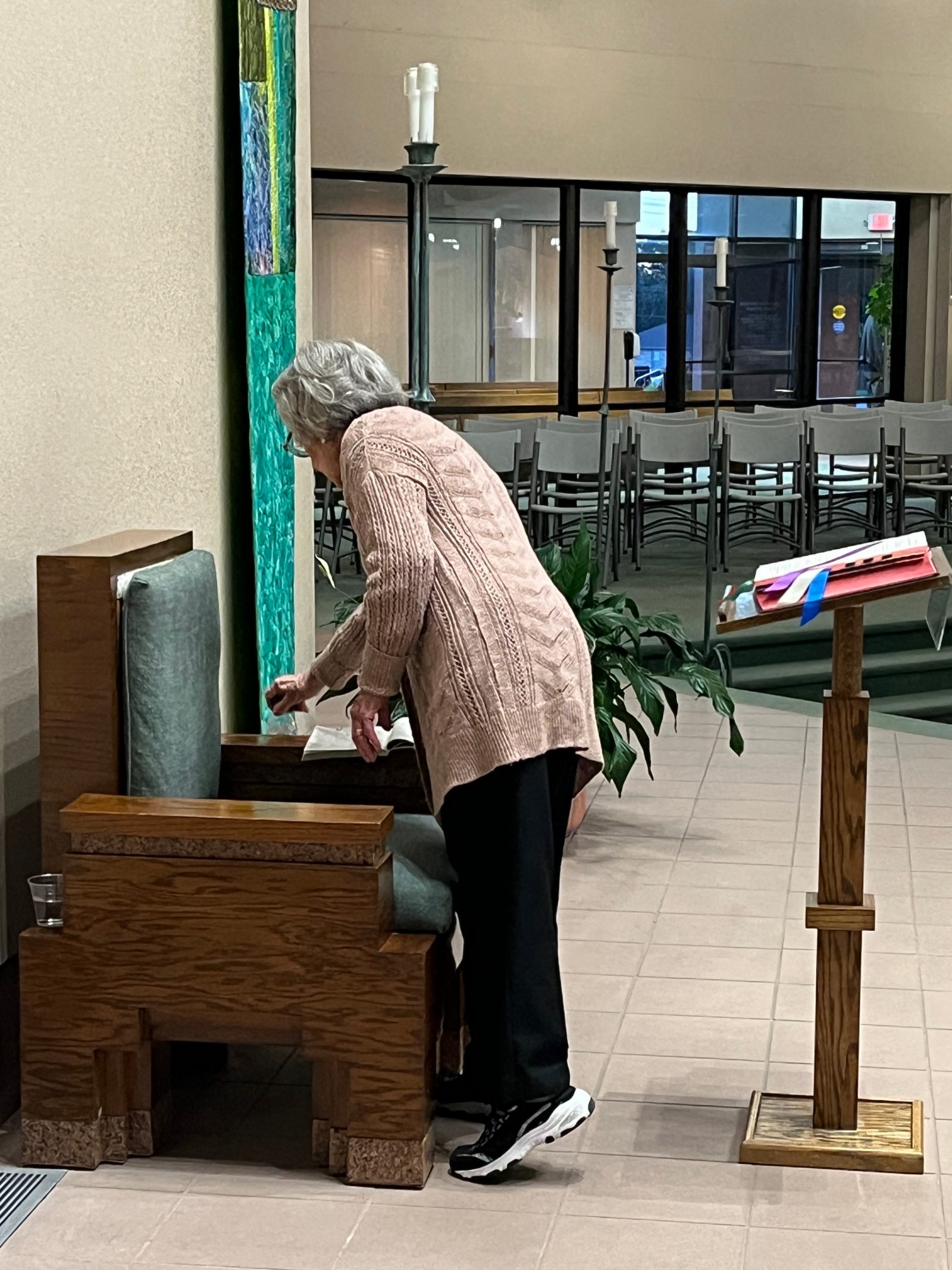 A woman dusts a chair inside a church