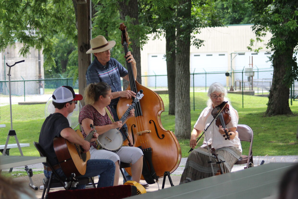 A quartet of musicians performs in a park