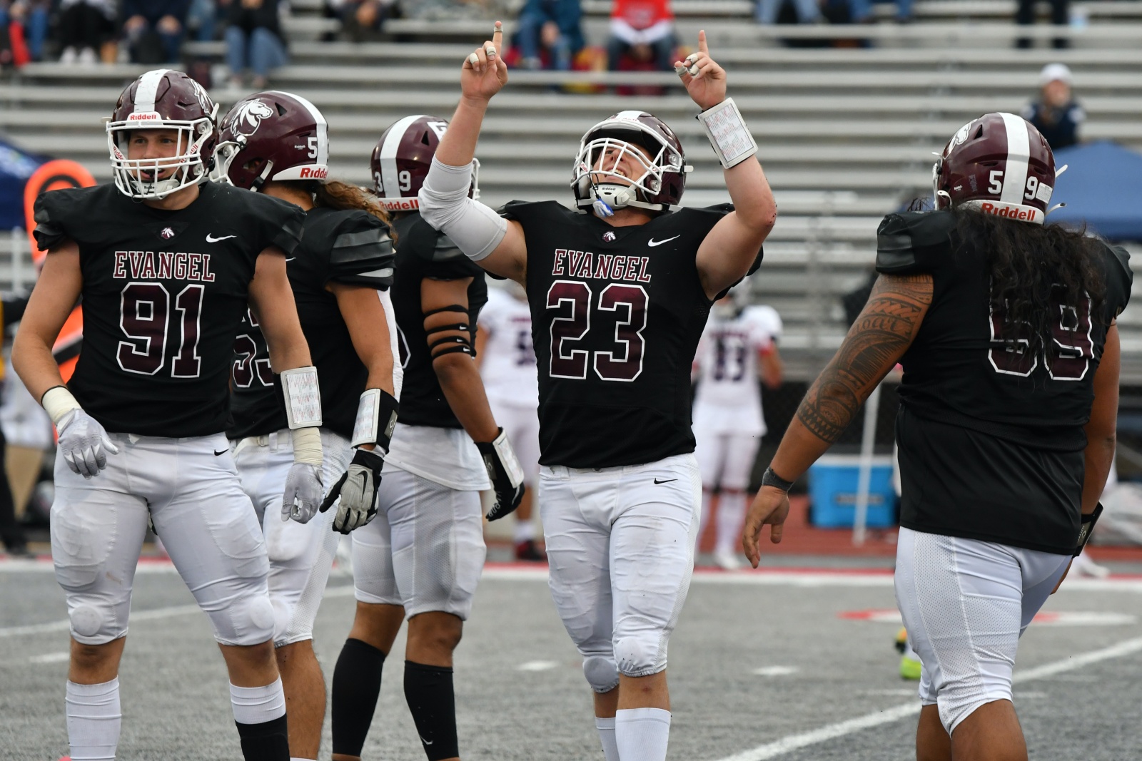 Bradley Myers, wearing an Evangel University football uniform, celebrates by pointing to the sky during a game