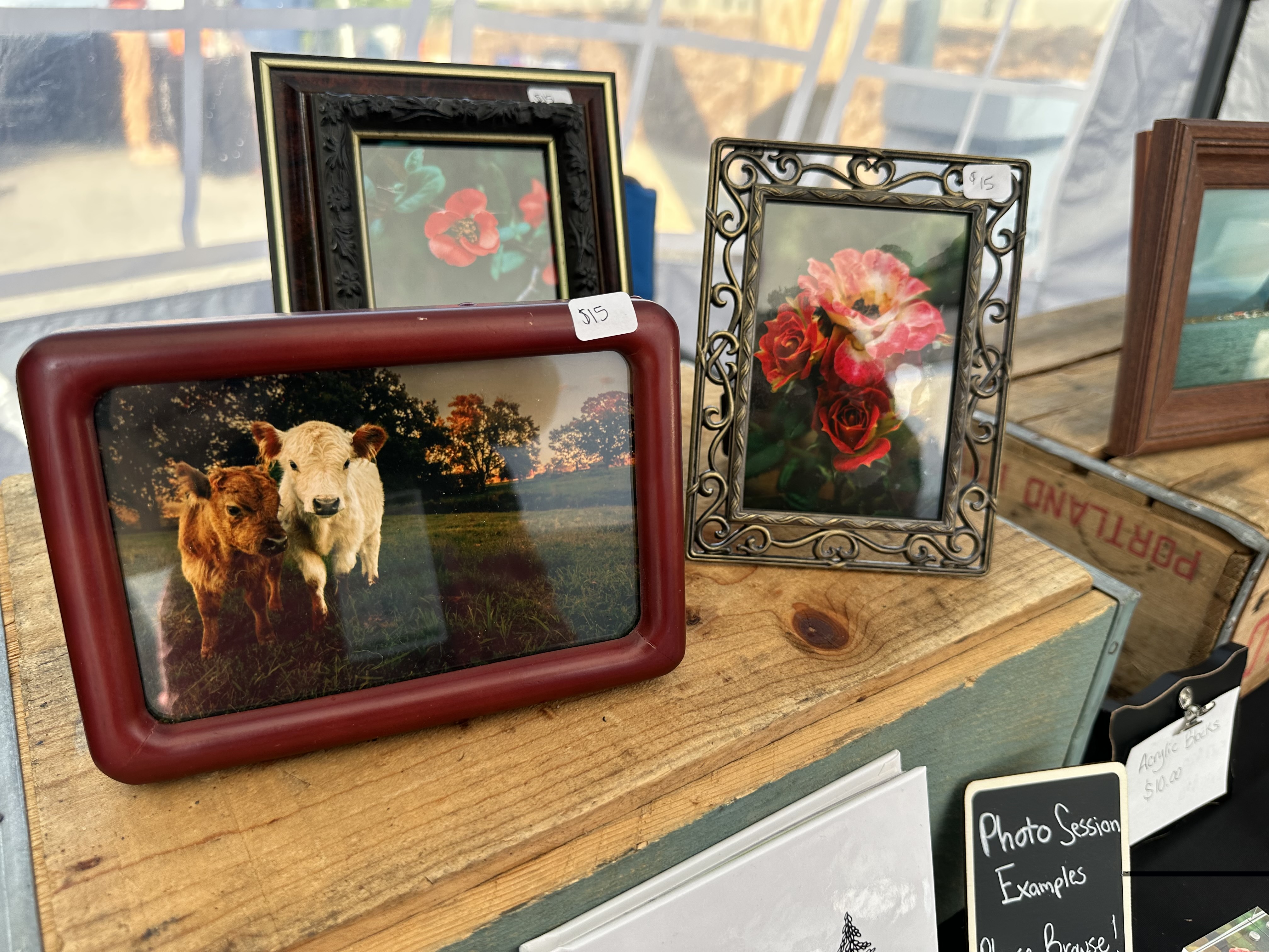 Three framed photographs sit on a wooden table top