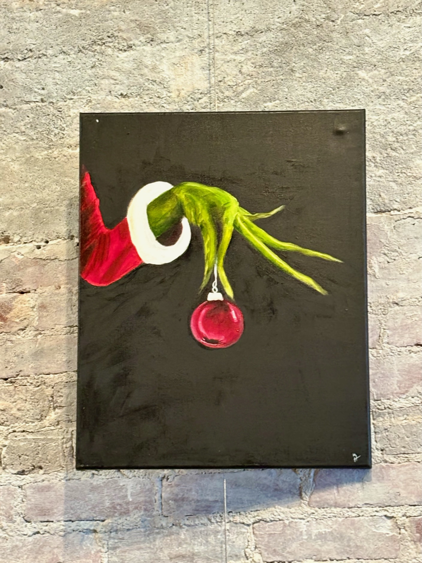 A painting of the Grinch's hand holding an ornament