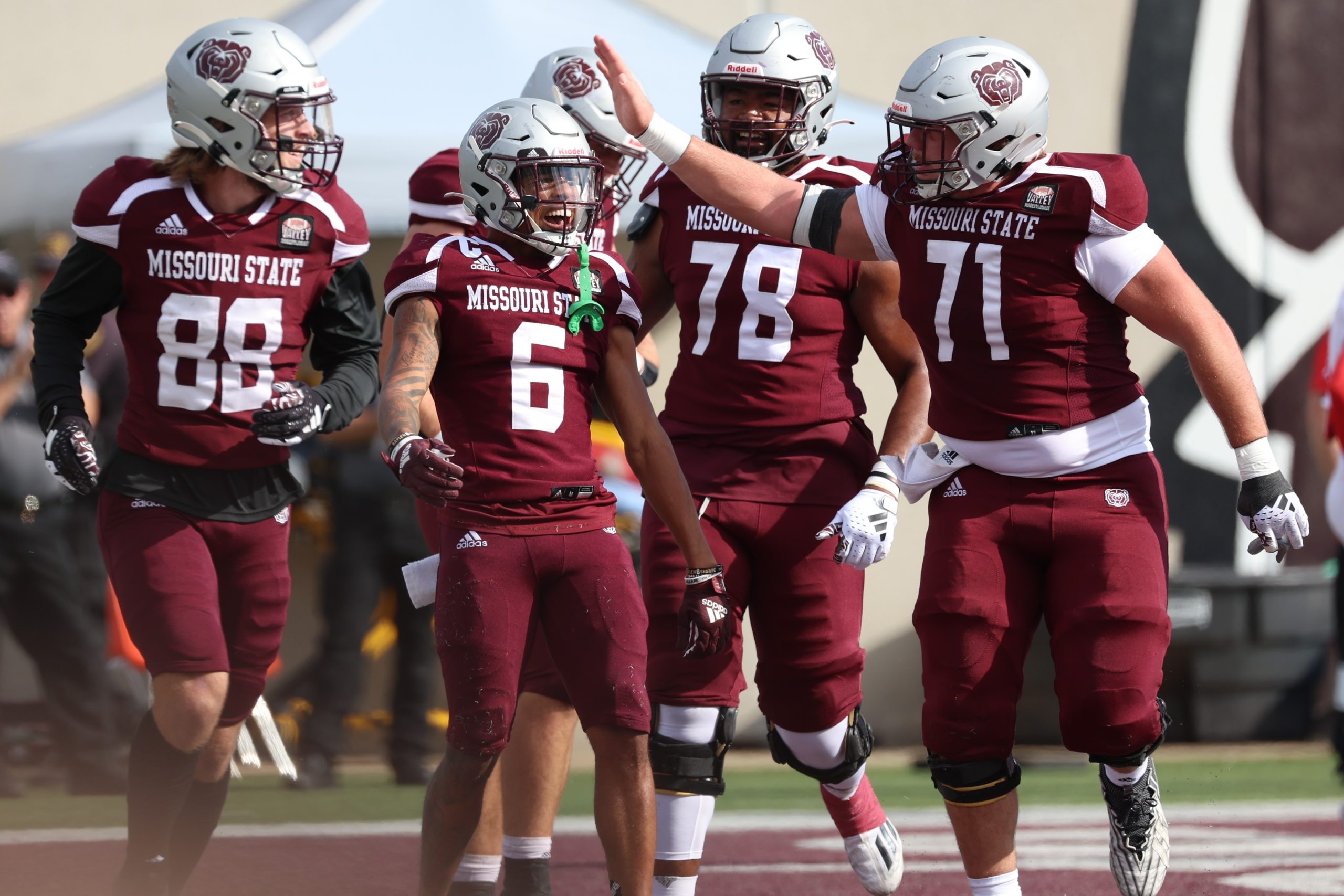 A group of Missouri State football players celebrate a touchdown by Raylen Sharpe