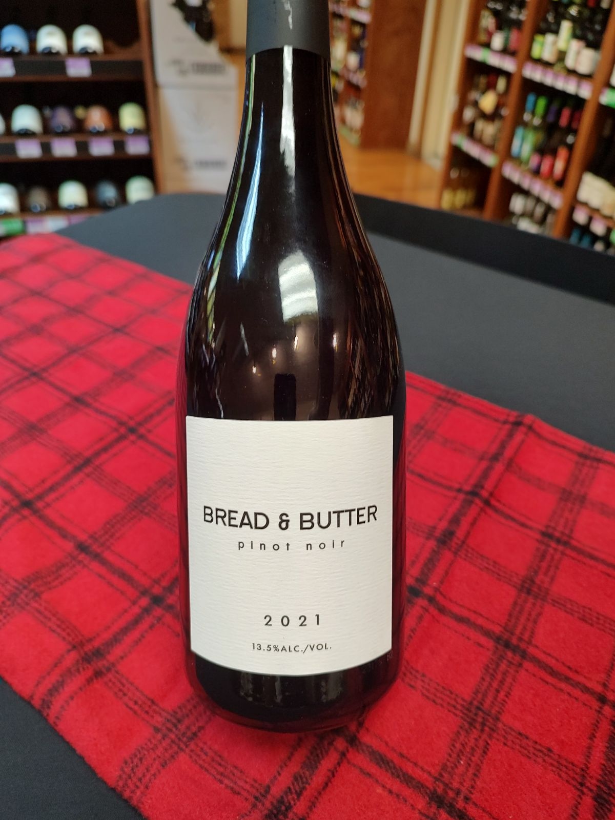 A bottle of Bread & Butter Pinot Noir sits on a table inside Macadoodles