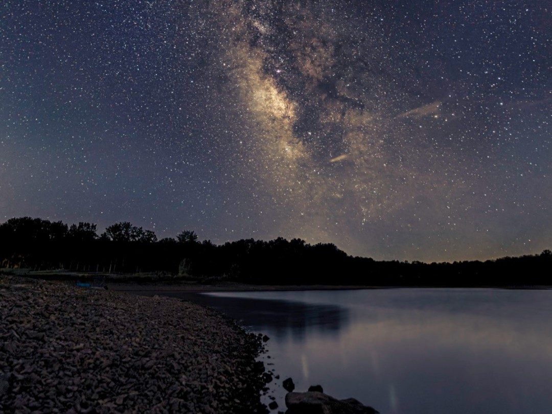 A photograph of a starry sky above a lake