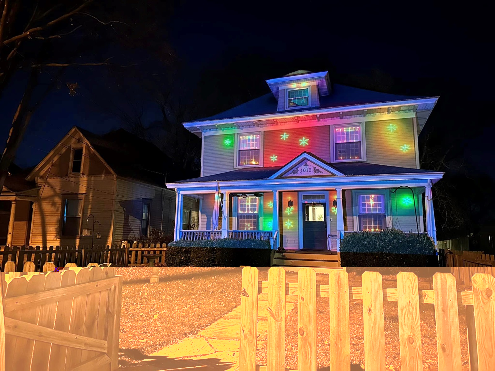 A Christmas display is projected onto the front of a two-story house
