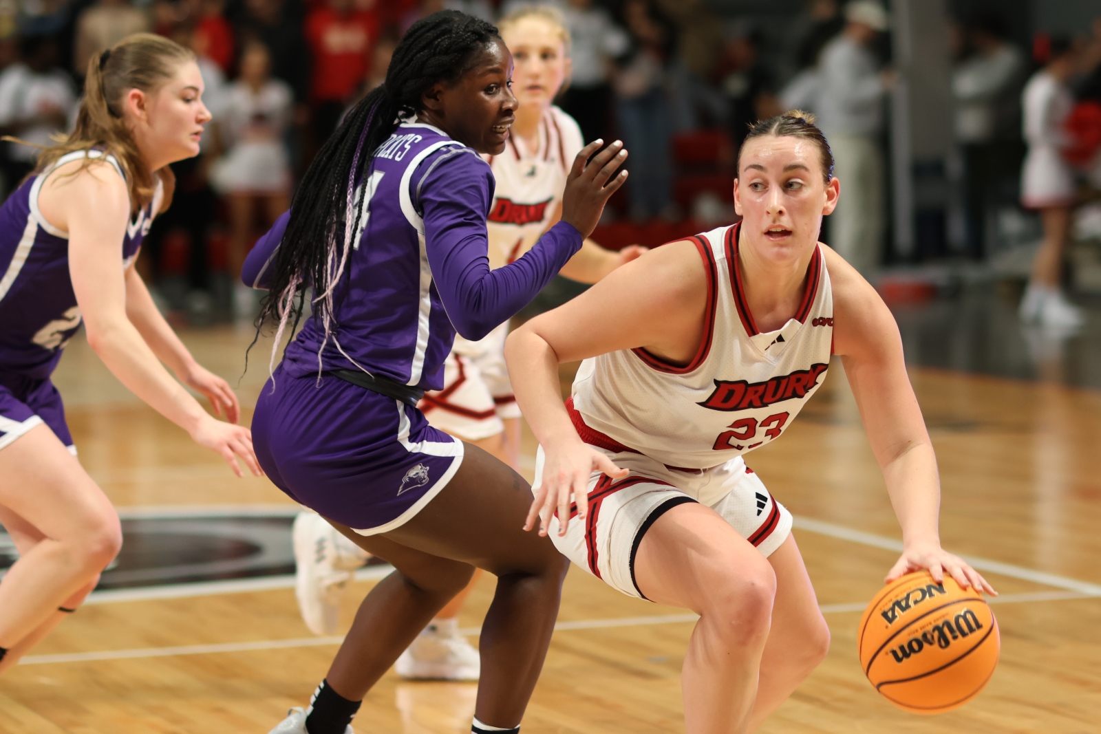 Reese Schaaf, wearing a Drury Lady Panthers basketball uniform, dribbles past a defender during a game.