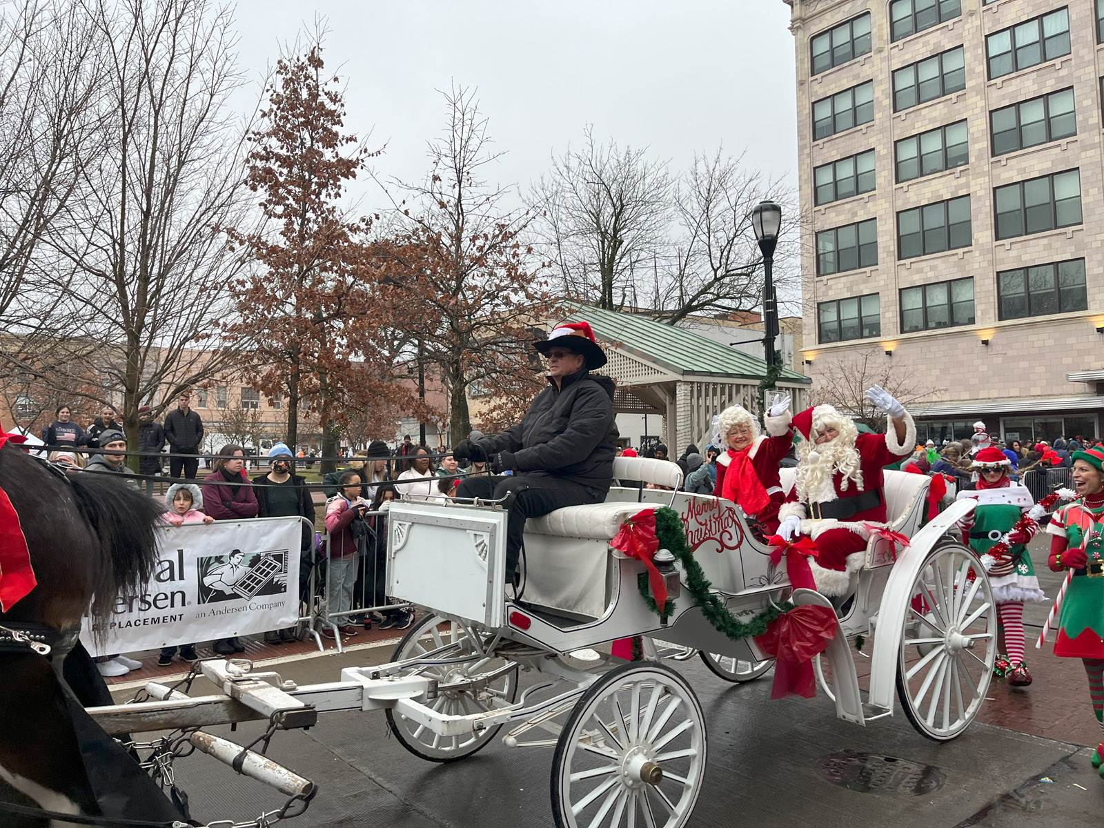 Santa Claus and Mrs. Claus ride through the 2022 Downtown Springfield Christmas Parade in a horse-drawn carriage